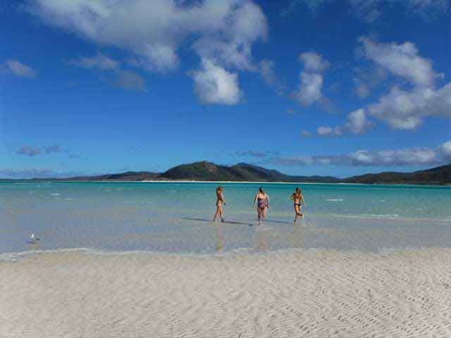 3 girls running into the ocean in the Whitsunday islands