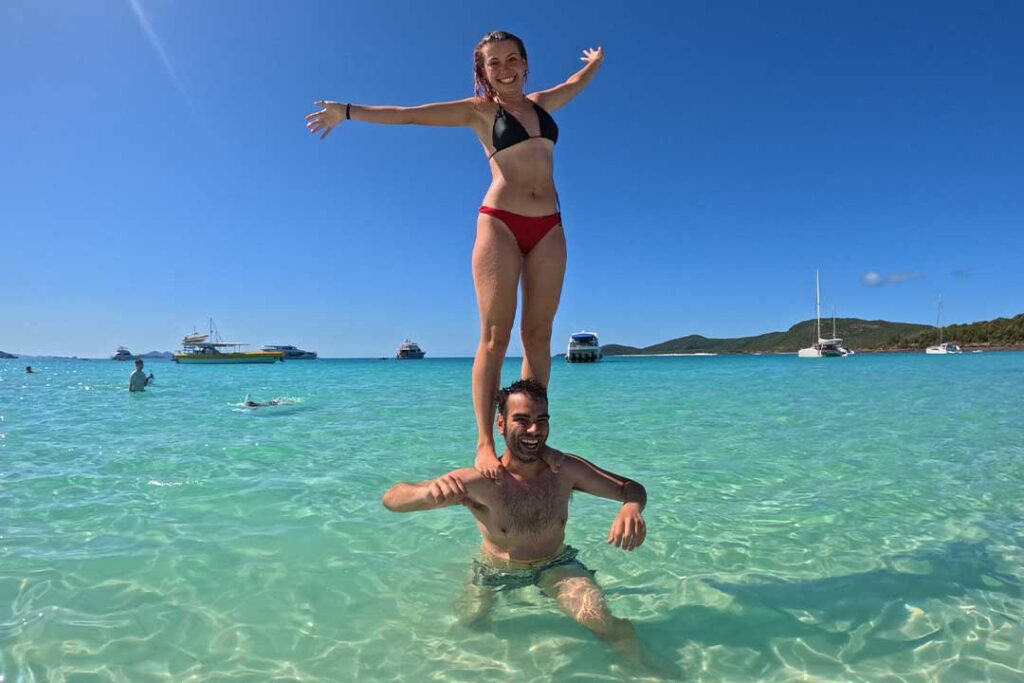 2 people playing in the clear ocean at Whitehaven Beach
